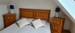 a bedroom with a bed with two night stands and two lamps at TI BIHAN TIEGUEZH in Île de Batz