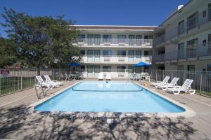 einem Pool vor einem Gebäude mit Liegestühlen in der Unterkunft Motel 6-Roseville, MN - Minneapolis North in Roseville