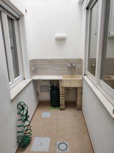 baño con lavabo y 2 ventanas en Apartments Villas Cagliari, en Cagliari