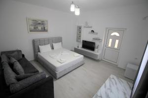 a small living room with a bed and a couch at Vila Melina in Ksamil