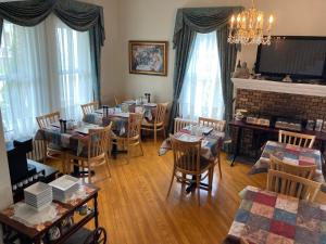 uma sala de jantar com mesas e cadeiras e uma lareira em Chez l'Doc em Saint-Prosper