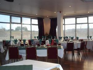 una sala per banchetti con tavoli, sedie e finestre di B&B The Silver Eel a Strokestown
