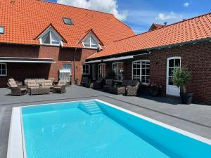 a swimming pool in front of a brick house at Der Romantik-Hof Greetsiel in Greetsiel