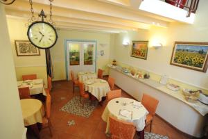 a restaurant with tables and a clock on the wall at Hotel Mediterraneo in Syracuse