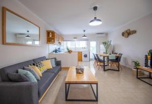a living room and kitchen with a couch and a table at Arioso apartment in the center of Zakynthos town in Zakynthos Town