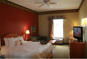 a hotel room with a bed and a television at Hampton Inn Laplace in Laplace