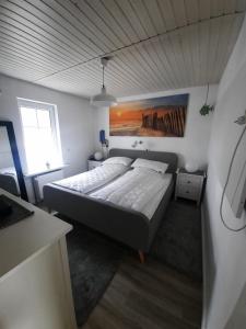 a bedroom with a large bed with a painting on the wall at Ferienbungalow FeWo Eutin Süsel Sierksdorf Strand Ostsee in Süsel