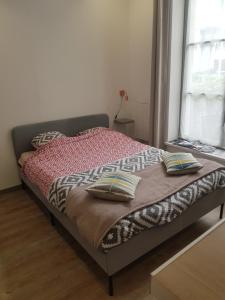 uma cama com duas almofadas num quarto em Lille centre parking privé gratuit très calme em Lille