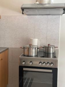 2 ollas sobre una estufa en la cocina en Casa Blanca II en Pyrgos Dirou
