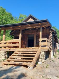 a log cabin with a staircase in front of it at Agroturystyka LipoweWzgórze domek Antek in Tereszpol