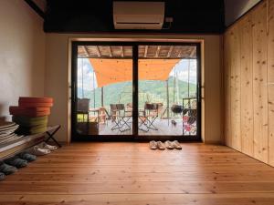 a room with a large glass door leading to a patio at 古民家グランピングMatoba in Miyoshi