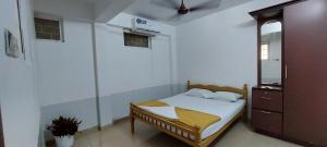 ein kleines Schlafzimmer mit einem Bett und einem Spiegel in der Unterkunft Jinan palace guest house Jinan palace guest house in Nedumbassery