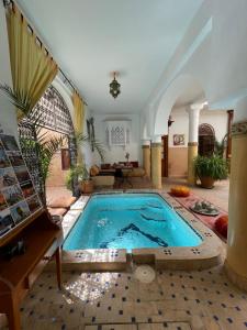 una grande piscina in una stanza con una grande stanza di Riad La Calèche & SPA a Marrakech