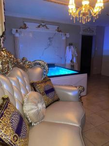 een kamer met een bank en een tafel met een zwembad bij Le Petit Versailles in Vernon