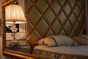 een slaapkamer met een spiegel, een bed en een lamp bij Le Petit Versailles in Vernon
