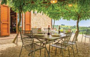 a wooden table with chairs and a table with wine bottles at Certinuzza in Luia