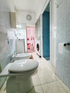 a bathroom with a toilet and a sink and a washing machine at Nei pressi del mare in Termoli