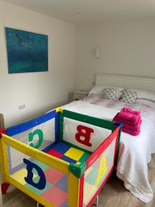 a childs bedroom with a bed with a colorful crib at The Boat House in Chichester