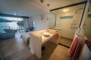 a bathroom with a bed and a sink and a shower at Asalem in Abraão