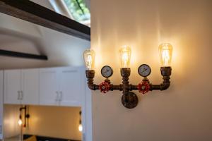 a light fixture on the wall with clocks on it at Eakley Stables 2 - Pogo in Newport Pagnell