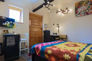 Schlafzimmer mit einem Bett, einem Schreibtisch und einem Tisch in der Unterkunft Eakley Stables 2 - Pogo in Newport Pagnell