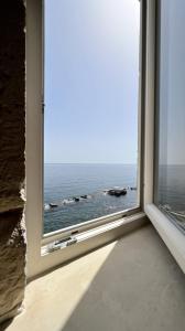an open window with a view of the ocean at Great Charme in Siracusa