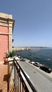 a balcony of a building with a view of the ocean at Great Charme in Siracusa