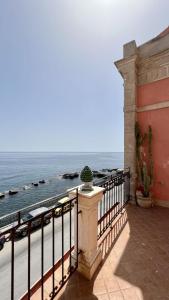 a balcony with a view of the ocean at Great Charme in Siracusa