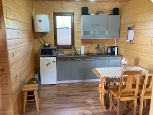 a kitchen with a table in a wooden cabin at "U Kamińskich" in Przyborów
