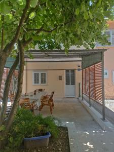 a patio with a table and chairs in front of a building at Apartmani Ana in Tivat