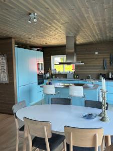a kitchen with a large white table and chairs at Torvholmen in Fosnavåg