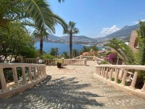 a walkway with palm trees and a view of the water at Kalkan lovely 1 bedroom holiday rental in Kas