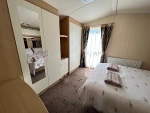 a small bedroom with a bed and a window at Dragonfly Lodge in South Cerney