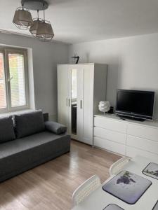 een woonkamer met een bank en een tv bij Apartament Olsztyńska Giżycko in Giżycko