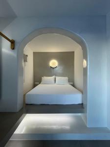 um quarto com uma cama branca num arco em Villa Anna Maria em Mylopotas