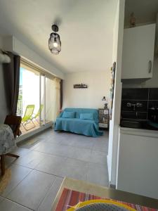 uma sala de estar com uma cama azul e uma cozinha em LE PROVENCAL - Hyper centre - Clim - Terrasse em Cassis