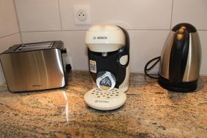 a coffee maker and a toaster on a counter at L'instant T 4* Balnéo, Sauna et Parking Privé in Colmar