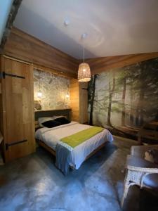 a bedroom with a bed and a painting on the wall at Green Ecolodge in La Colmiane