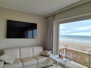 a living room with a couch and a view of the beach at Kristof701 in De Panne