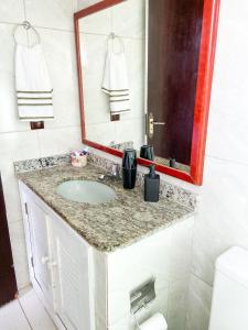 a bathroom with a sink and a mirror at Apart hotel a 150m da praia de Geribá in Búzios