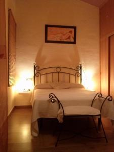 ein Schlafzimmer mit einem Bett und einem Stuhl mit Beleuchtung in der Unterkunft FUNDADORES, Isla Cristina in Isla Cristina
