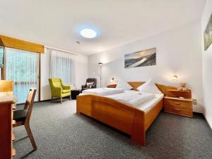a bedroom with a bed and a desk and a chair at Weinhaus am Schieferfels in Veldenz