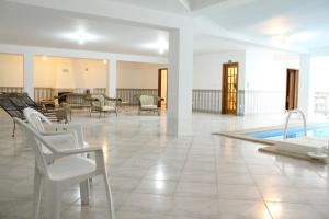 a lobby with a swimming pool and chairs and a swimming pool at Canas Beach House - AL in Areia Branca