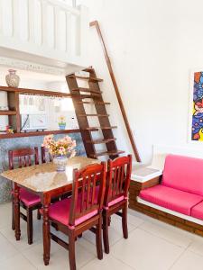 a dining room with a table and chairs and a staircase at Apart hotel a 150m da praia de Geribá in Búzios