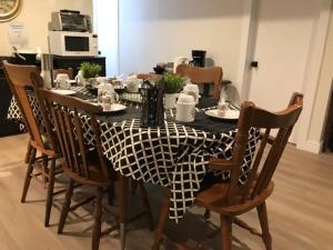 a dining room table with a black and white table cloth at Gîte La Nuitée in Coaticook