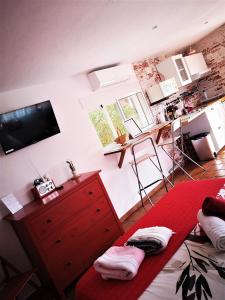 a bedroom with a red dresser and a bed with a red blanket at CASA MARTINEZ Studios & Chambre d'Hôtes à 3 kms de MONTSERRAT VALENCIA in Montroy