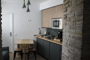 a kitchen with a table and a microwave and a brick wall at La Cúpula in Córdoba