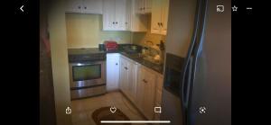 a kitchen with white cabinets and a stainless steel refrigerator at Luxury Villa rentals in Montego Bay +9 photos