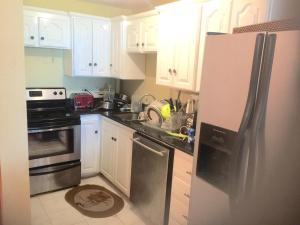 a kitchen with white cabinets and a stainless steel refrigerator at Luxury Villa rentals in Montego Bay