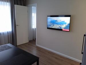 ein Wohnzimmer mit einem Flachbildfernseher an der Wand in der Unterkunft Harmonija in Ludza